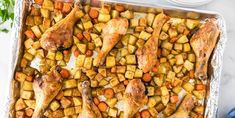 chicken, potatoes and carrots in a baking dish on a marble counter top with a blue towel