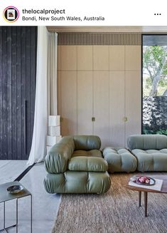 a living room with two couches and a table in front of a large window