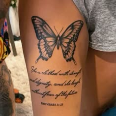 a woman's arm with a butterfly tattoo and bible verse written on the side