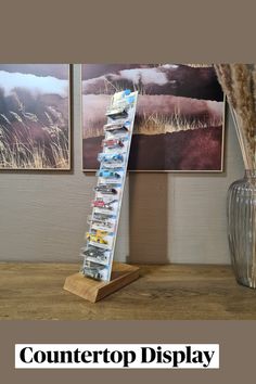 a wooden table with two vases and pictures on the wall behind it that says countertop display