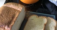 a loaf of bread sitting on top of a cutting board next to an orange bowl