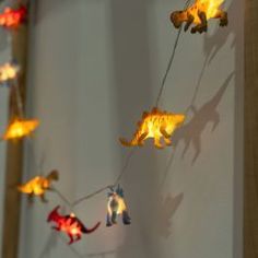 some lights that are on the side of a wall with animals hanging from it's sides