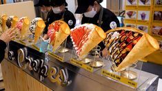 people wearing masks are buying ice cream at a store