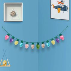 a string of pineapples is hanging on a blue wall next to other items