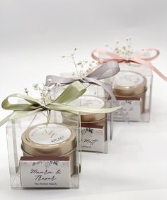 three small jars with labels on them and ribbons tied around the lids, sitting next to each other