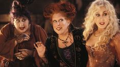 three women dressed as witches posing for a photo