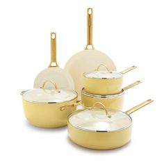 a set of yellow pots and pans with gold handles