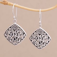 These sterling silver dangle earrings have an elegant curved diamond shape. Bali's Dewa Arimbawa handcrafts the pair with elaborate detailed scroll work. Formal Engraved Dangle Earrings, Sterling Silver Dangle Jewelry With Intricate Design, Elegant Engraved Dangle Earrings, Ornate Engraved Sterling Silver Earrings, Elegant Engraved Drop Earrings, Artisan Sterling Silver Earrings With Intricate Design, Artisan Engraved Dangle Earrings, Nickel Free Silver Diamond-shaped Jewelry, Classic Intricate Dangle Earrings