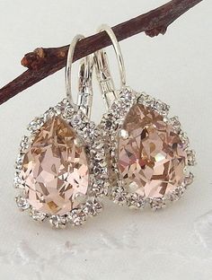 two pairs of earrings are hanging from a branch