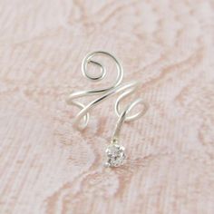 This earring features a cubic zirconia crystal drop on a wire wrapped, no piercing ear cuff making this sterling silver CZ drop ear cuff. All metals on this ear cuff are sterling silver. Listing is for one ear cuff. - 2.5mm CZ crystal - Ear cuff diameter is approximately 10mm My Shop: http://simplicitycharms.com Adjustable Silver Ear Cuff With Ear Wire, Silver Cubic Zirconia Ear Cuff As Gift, Adjustable Sterling Silver Ear Cuff, Sterling Silver Ear Cuff With Ear Wire For Weddings, Sterling Silver Ear Cuff For Wedding, Sterling Silver Single Ear Cuff For Wedding, Adjustable Sterling Silver Ear Cuff With Ear Wire, Wedding Sterling Silver Single Ear Cuff, Silver Teardrop Ear Cuff Single Earring