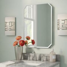 a bathroom with a sink, mirror and flowers on the counter