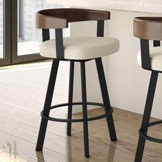 two modern bar stools in front of a window