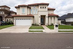 a two story house with a car parked in front of the garage door and driveway