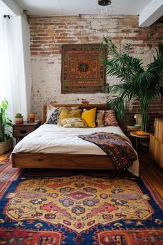 a bedroom with a bed, rugs and plants on the floor in front of a brick wall