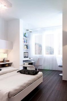 a modern bedroom with white walls and wood flooring