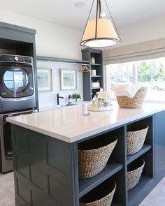 a kitchen island with baskets on it and a washer dryer in the background