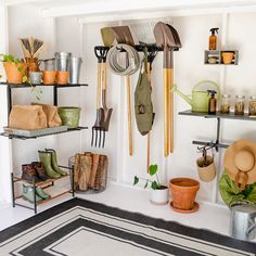 a room filled with lots of pots and gardening tools hanging from the wall next to each other