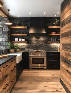 a kitchen with wood floors, black cabinets and stainless steel stove top oven in the center