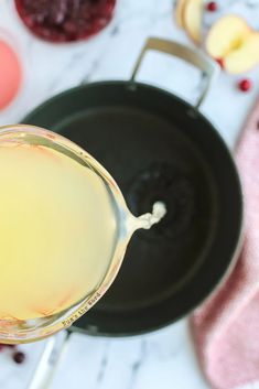 an apple cider is sitting in front of some fruit