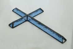 a cross made out of glass sitting on top of a table