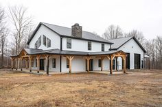 a large white house sitting on top of a dry grass covered field next to trees