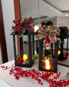 two lanterns decorated with bows and candles on a table