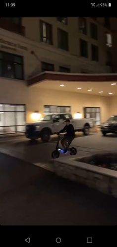 a man riding a skateboard down the middle of a street at night time,