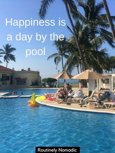 people are sitting on lounge chairs by the pool with umbrellas and sunbathers