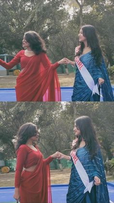 two women in red and blue dresses shaking hands