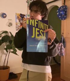 a boy holding up a book in front of his face