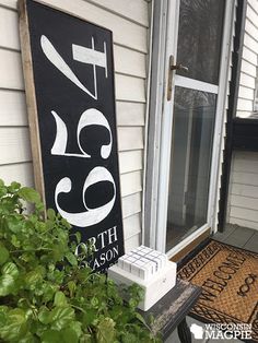 a black and white sign sitting on the side of a house