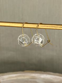 "Faceted glass drop earrings on a 14K gold filled hammered wire loop with back closure. These unique glass drops have the look of a faceted stone but are very light weight and comfortable to wear everyday.  Earrings measure 1.25\" in height from the top of the wire to the bottom of the drop and .5\" wide. Also you can visit my facebook page here: fb.me/T.JoyDesigns" Delicate Faceted Gold Earrings, Minimalist Glass Jewelry With Ear Wire, 14k Gold Filled Faceted Drop Earrings, Glass Earrings With Faceted Beads For Gift, Clear Glass Jewelry With Faceted Beads, Teardrop Glass Earrings With Ear Wire, Gold Wire Wrapped Glass Earrings, Hammered 14k Gold-filled Drop Earrings, Bubble Earrings