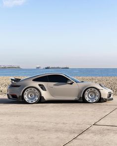 a grey car parked in front of the ocean