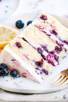 a slice of lemon blueberry cake on a white plate with a fork next to it