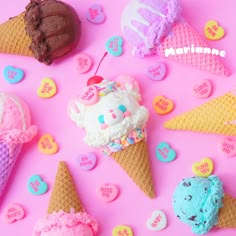 ice cream cones are arranged on a pink surface with hearts and candies around them