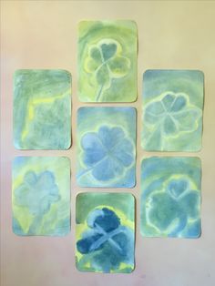 four square coasters with blue and green designs on them, one is painted in the same color as the other