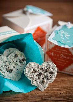 two heart shaped cookies sitting in a bag next to each other on a wooden table