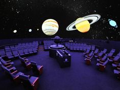 an empty auditorium with chairs and planets in the background