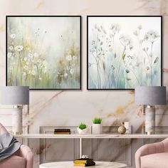 two paintings hanging on the wall in a living room with pink chairs and a coffee table