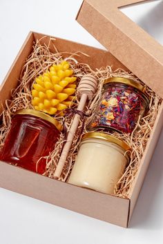 two jars of jam in a box with corn on the cob