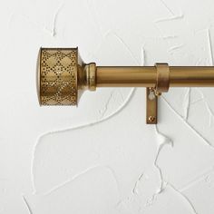 an old fashioned brass toilet paper holder on a white wall