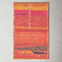 an orange and pink rug hanging on a wall