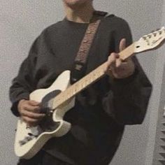 a young man is playing an electric guitar