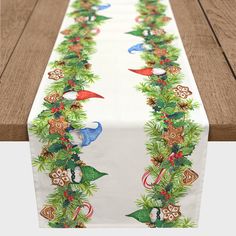 a long table runner with christmas decorations on the top and bottom, sitting on a wooden surface