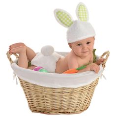 a baby in a basket with an easter bunny hat