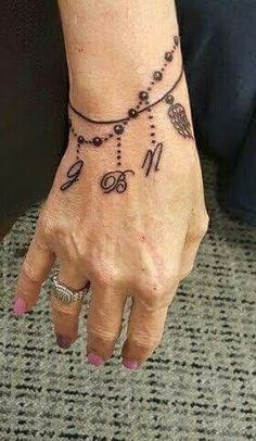 a woman's hand with a tattoo on her left wrist and the number nine