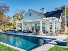 a house with a pool in the middle of it and an outdoor dining area next to it