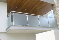 a balcony with glass railing and wooden ceiling