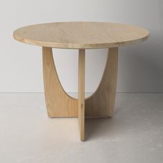 a round wooden table sitting on top of a white floor