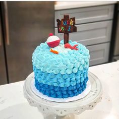 a blue and white cake with a wooden cross on top